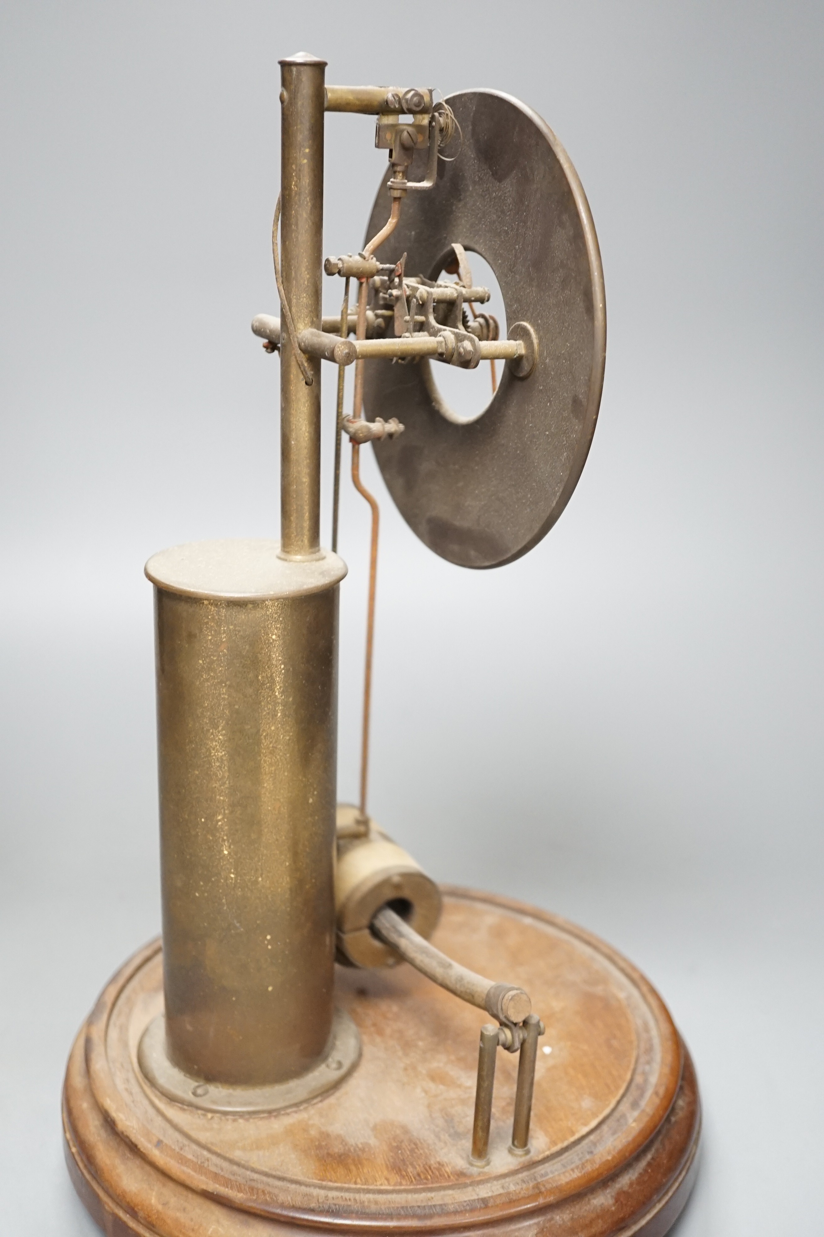 A Bulle electric pendulum clock, with large central brass pillar supporting the 14cm. dial, under a glass dome on a mahogany plinth